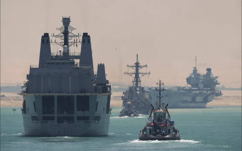 large-naval-ships-and-tugboats-sailing-through-narrow-waterway